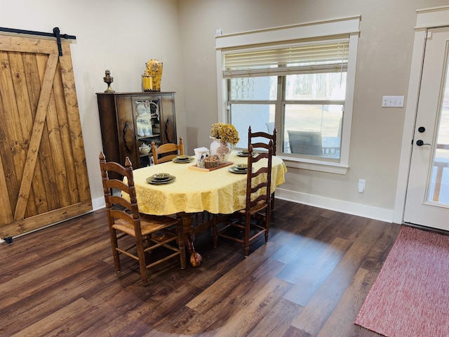 dining area with dark hardwood / wood-style flooring and a barn door