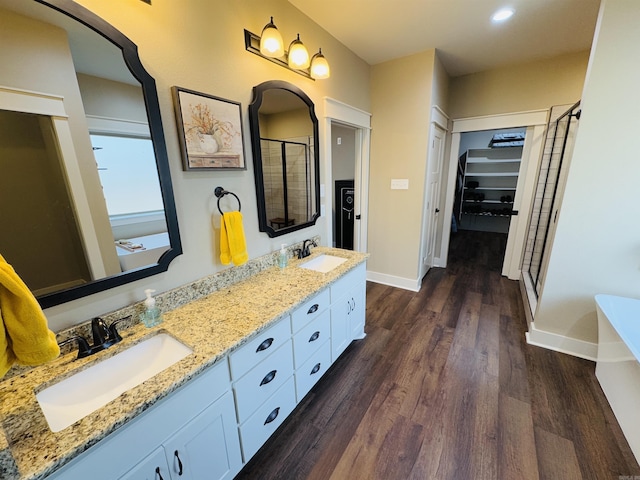 bathroom with vanity, a shower with shower door, and wood-type flooring