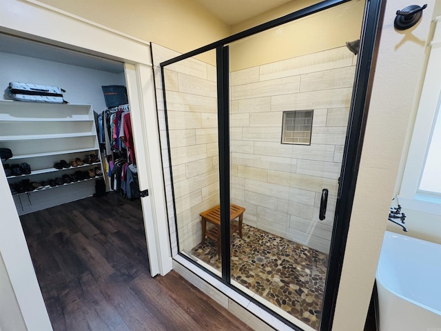 bathroom with wood-type flooring and a shower with door