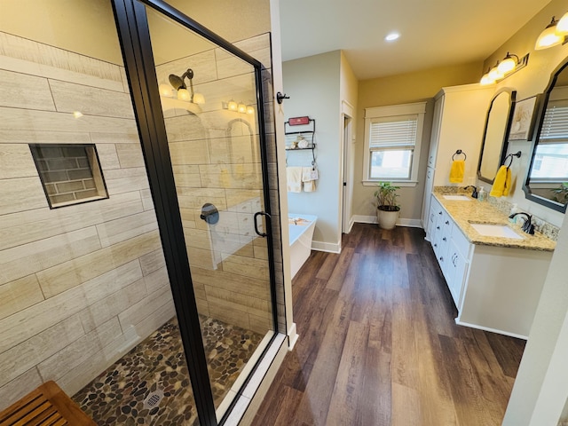 bathroom featuring vanity, hardwood / wood-style flooring, and shower with separate bathtub