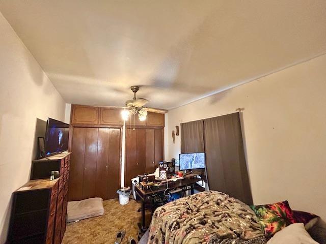 carpeted bedroom with two closets and ceiling fan