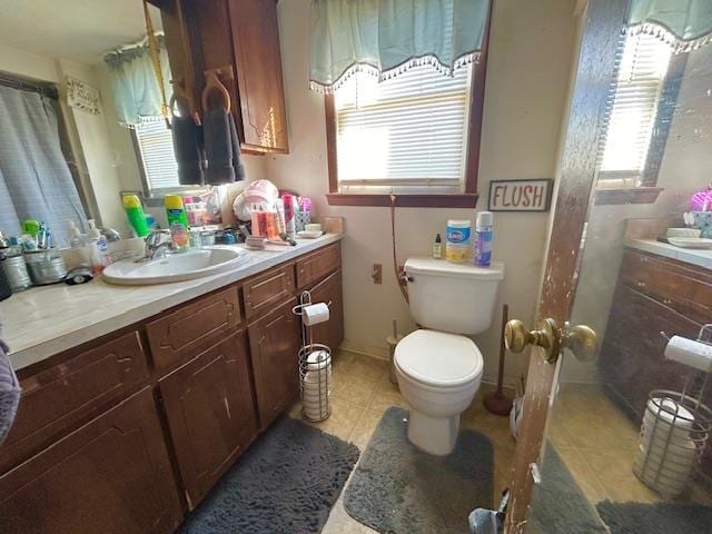 bathroom with vanity, toilet, and tile patterned flooring