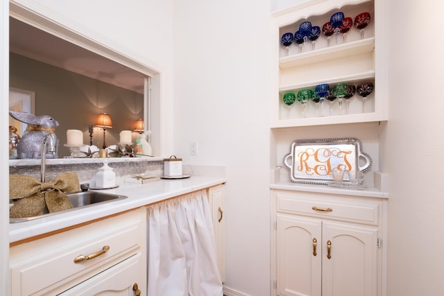 bar featuring sink and white cabinets