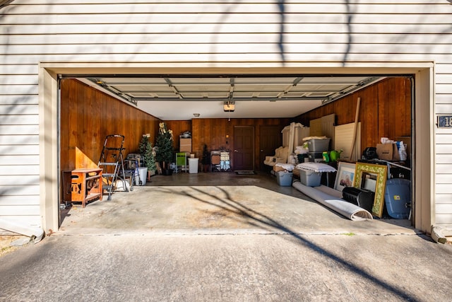 garage with a garage door opener and wooden walls