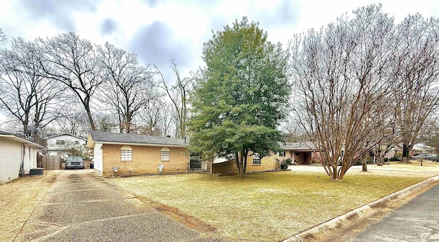 single story home featuring a front lawn, concrete driveway, and brick siding