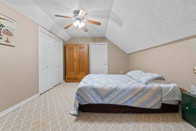 carpeted bedroom with ceiling fan, vaulted ceiling, and a textured ceiling