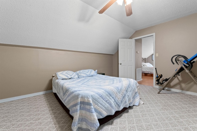 bedroom with vaulted ceiling, carpet, ceiling fan, and a textured ceiling