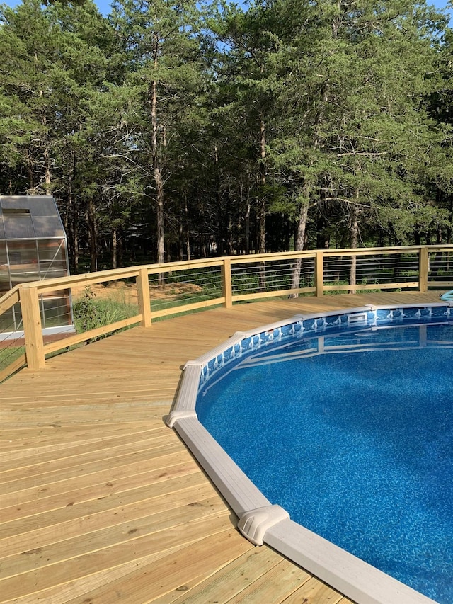 view of pool with an outbuilding and a wooden deck