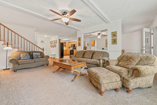 carpeted living room with ceiling fan and beam ceiling