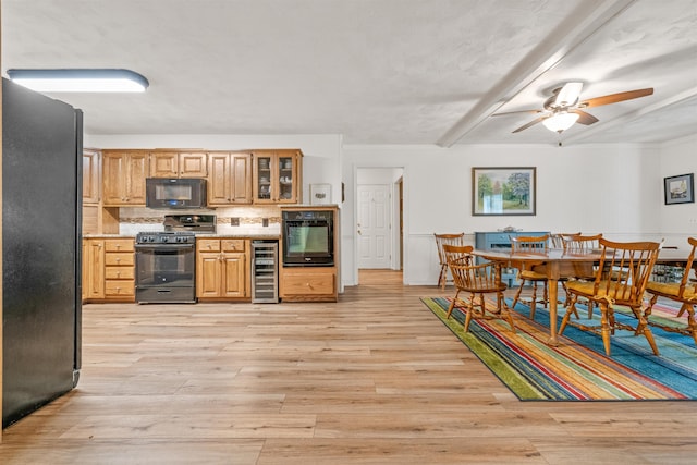 kitchen featuring ceiling fan, backsplash, black appliances, beverage cooler, and light wood-type flooring