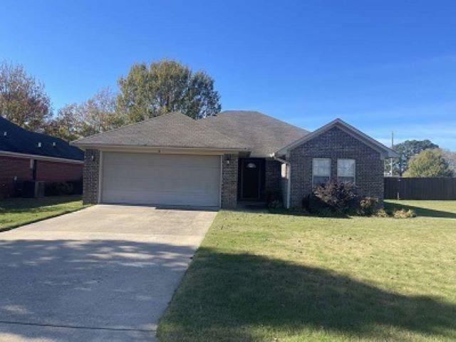 ranch-style home featuring a garage and a front lawn