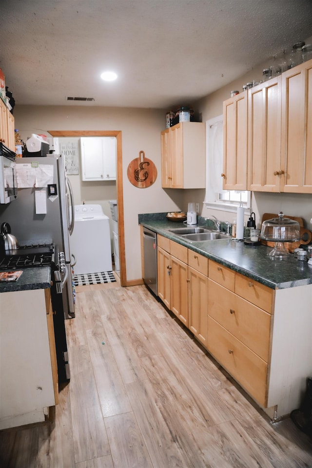 kitchen featuring sink, washer and dryer, light brown cabinets, stainless steel appliances, and light hardwood / wood-style floors