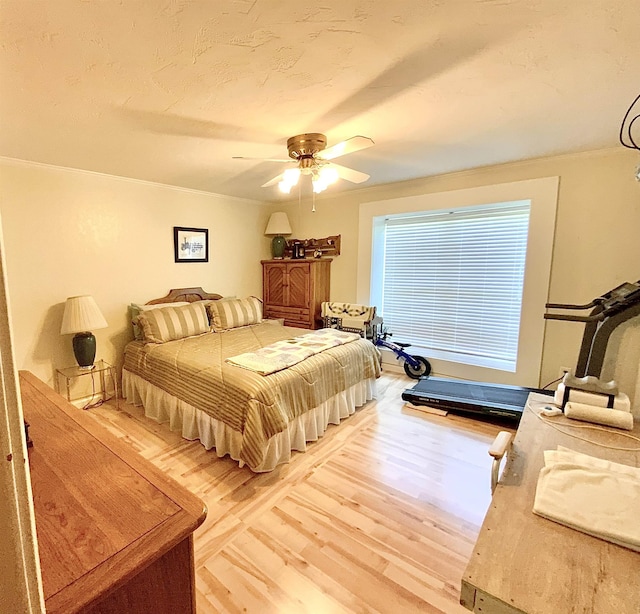 bedroom featuring hardwood / wood-style flooring, ornamental molding, and ceiling fan