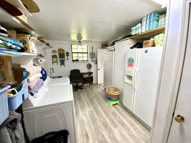 laundry room featuring washer and clothes dryer and light hardwood / wood-style flooring