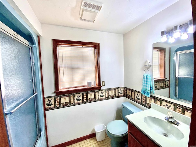 bathroom with vanity, a healthy amount of sunlight, and toilet