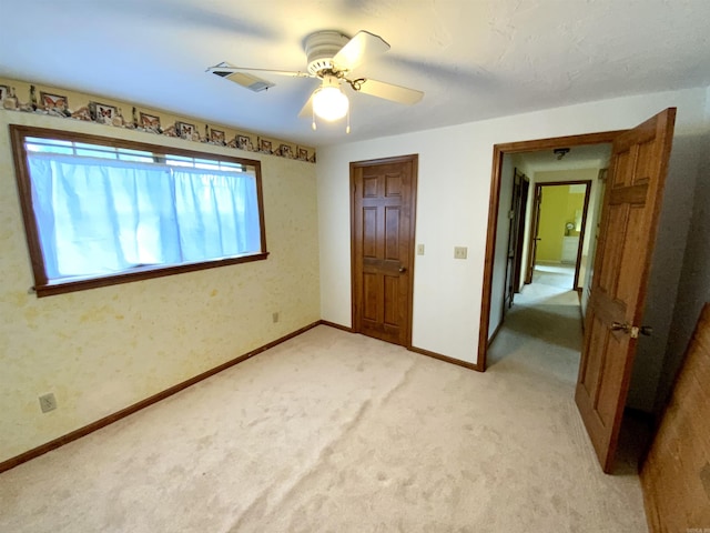 unfurnished bedroom with light colored carpet and ceiling fan