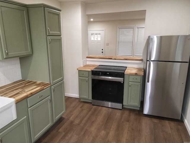 kitchen featuring butcher block countertops, range with electric stovetop, stainless steel refrigerator, and green cabinetry