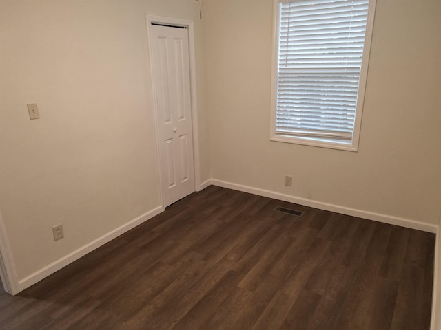 empty room with dark hardwood / wood-style flooring