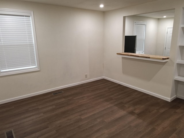 unfurnished room featuring dark wood-type flooring