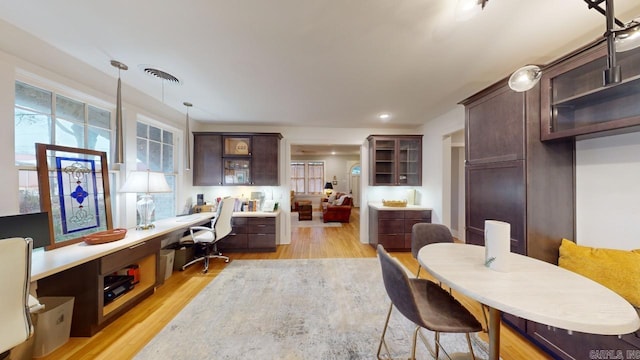 dining area featuring built in desk and light wood-type flooring