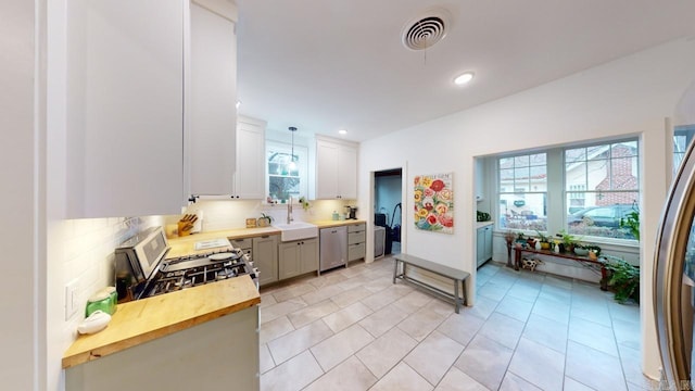 kitchen with stainless steel appliances, sink, pendant lighting, and decorative backsplash