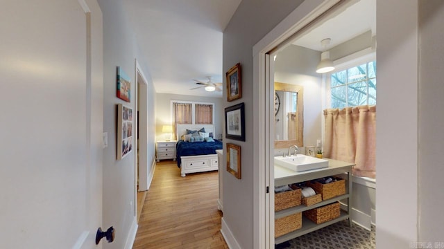 hallway featuring sink and light wood-type flooring