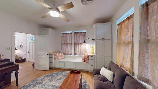 living area featuring light hardwood / wood-style floors and ceiling fan