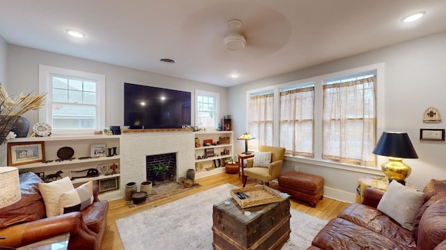 living room with light hardwood / wood-style flooring and ceiling fan