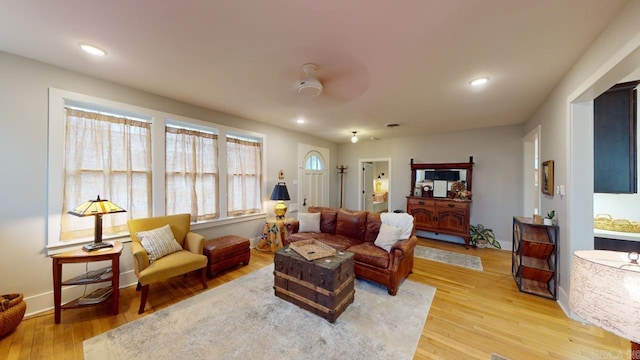 living room featuring ceiling fan and light hardwood / wood-style flooring