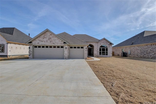 view of front of home with a garage and central AC