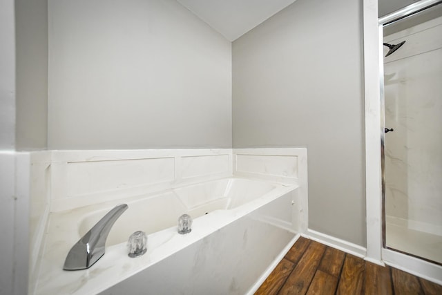 bathroom featuring hardwood / wood-style flooring, separate shower and tub, and lofted ceiling