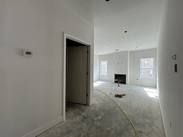 unfurnished living room with a fireplace and baseboards