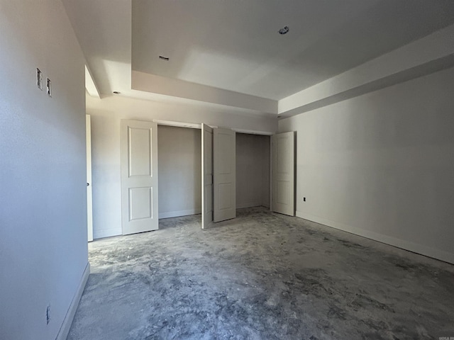 unfurnished bedroom with two closets and concrete floors