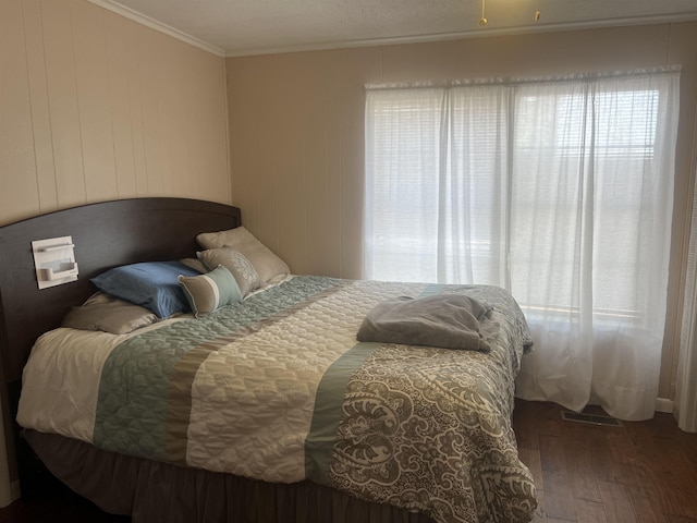 bedroom featuring ornamental molding and dark hardwood / wood-style floors