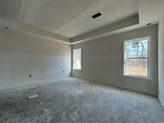 spare room with a raised ceiling and baseboards