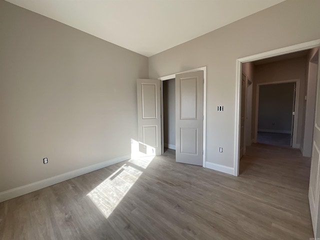 unfurnished bedroom with baseboards and wood finished floors