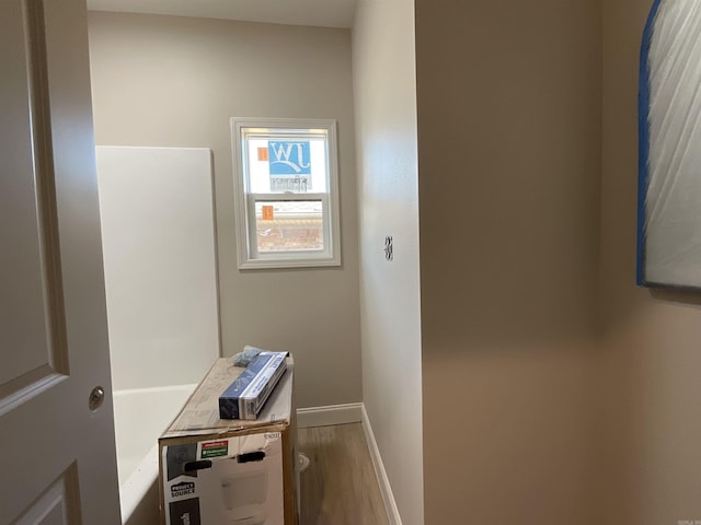 hallway featuring baseboards and wood finished floors