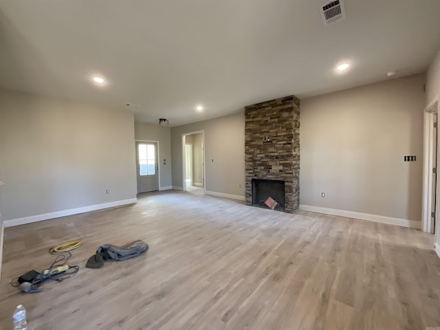 unfurnished living room featuring light wood-type flooring, visible vents, recessed lighting, a fireplace, and baseboards