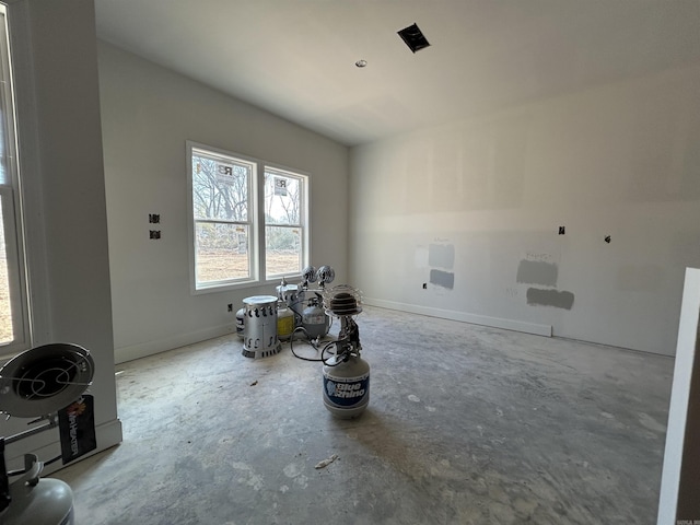 spare room featuring baseboards and concrete flooring