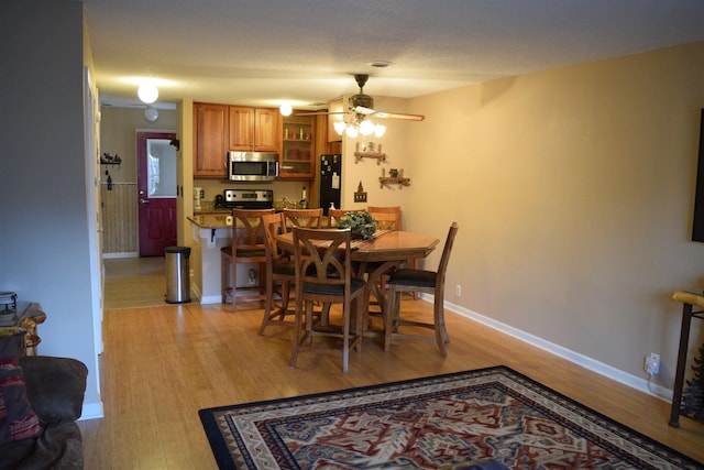 dining area with light hardwood / wood-style flooring and ceiling fan