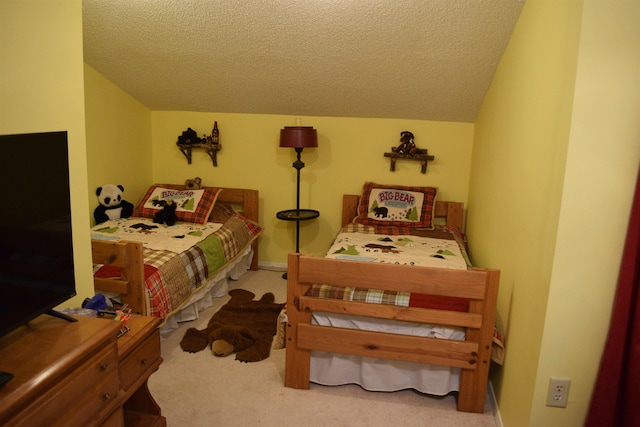 bedroom with vaulted ceiling, light carpet, and a textured ceiling