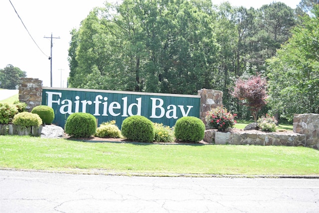 community / neighborhood sign featuring a lawn