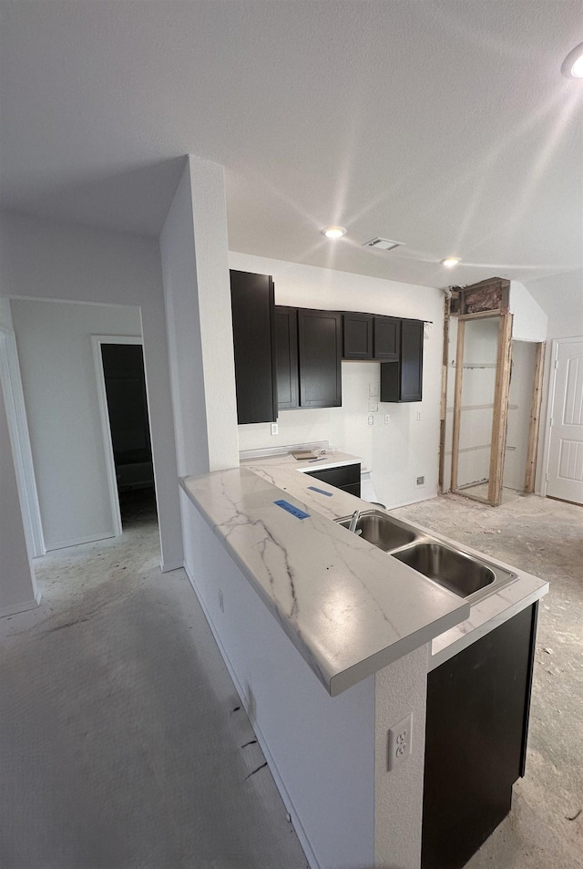 kitchen with kitchen peninsula, sink, and a textured ceiling