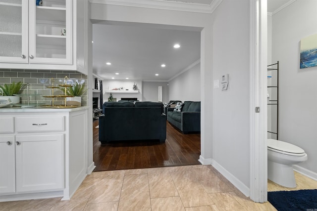 kitchen featuring white cabinetry, crown molding, and decorative backsplash