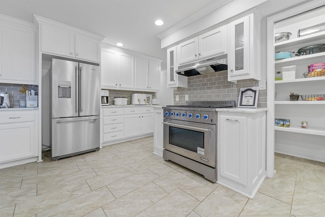 kitchen featuring white cabinetry, premium appliances, and backsplash