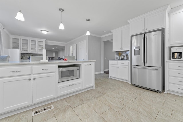 kitchen with pendant lighting, stainless steel appliances, and white cabinets