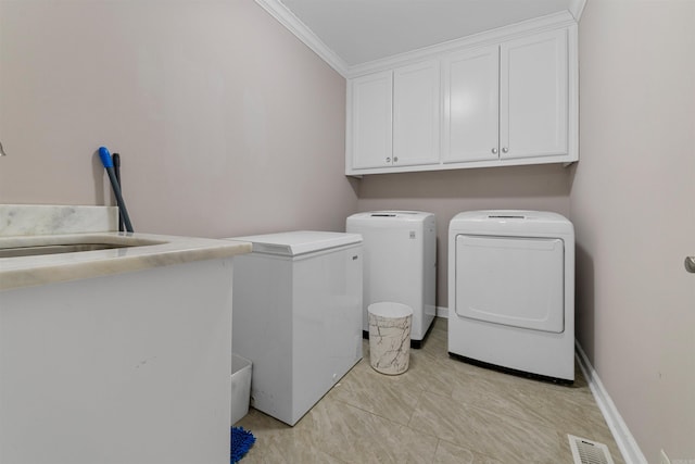 laundry area with cabinets, crown molding, washer and dryer, and sink