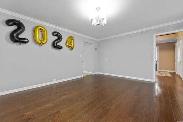 empty room featuring crown molding, dark wood-type flooring, and a notable chandelier