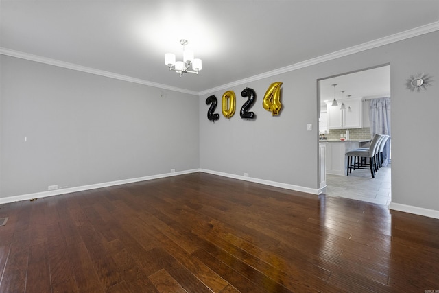 empty room with ornamental molding, wood-type flooring, and a chandelier