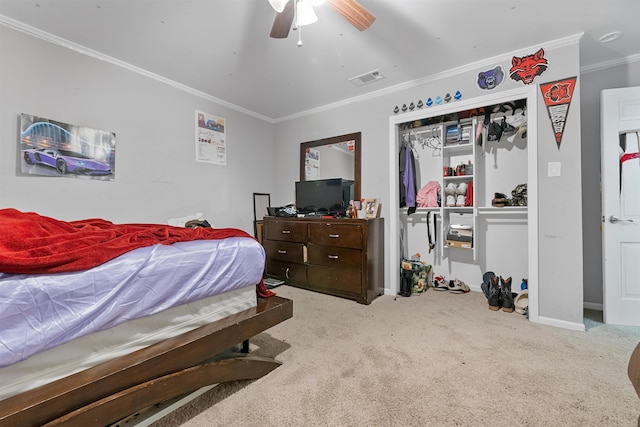 bedroom with crown molding, light colored carpet, ceiling fan, and a closet